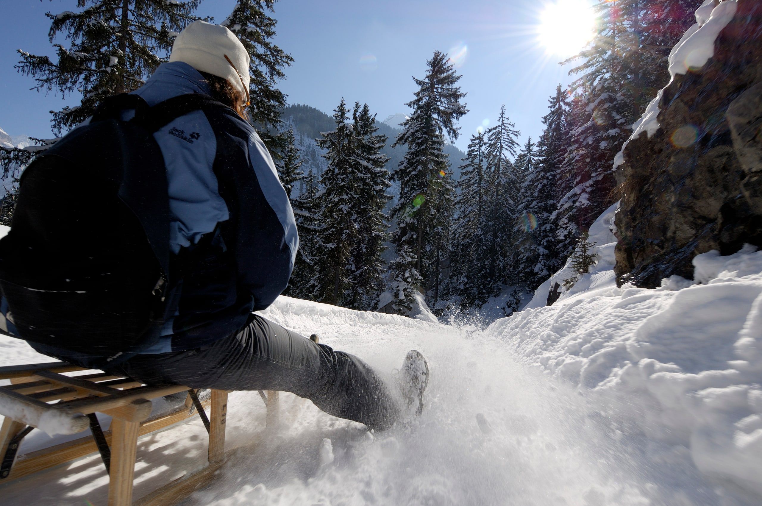 Schlittelfahrt durch den verschneiten Wald